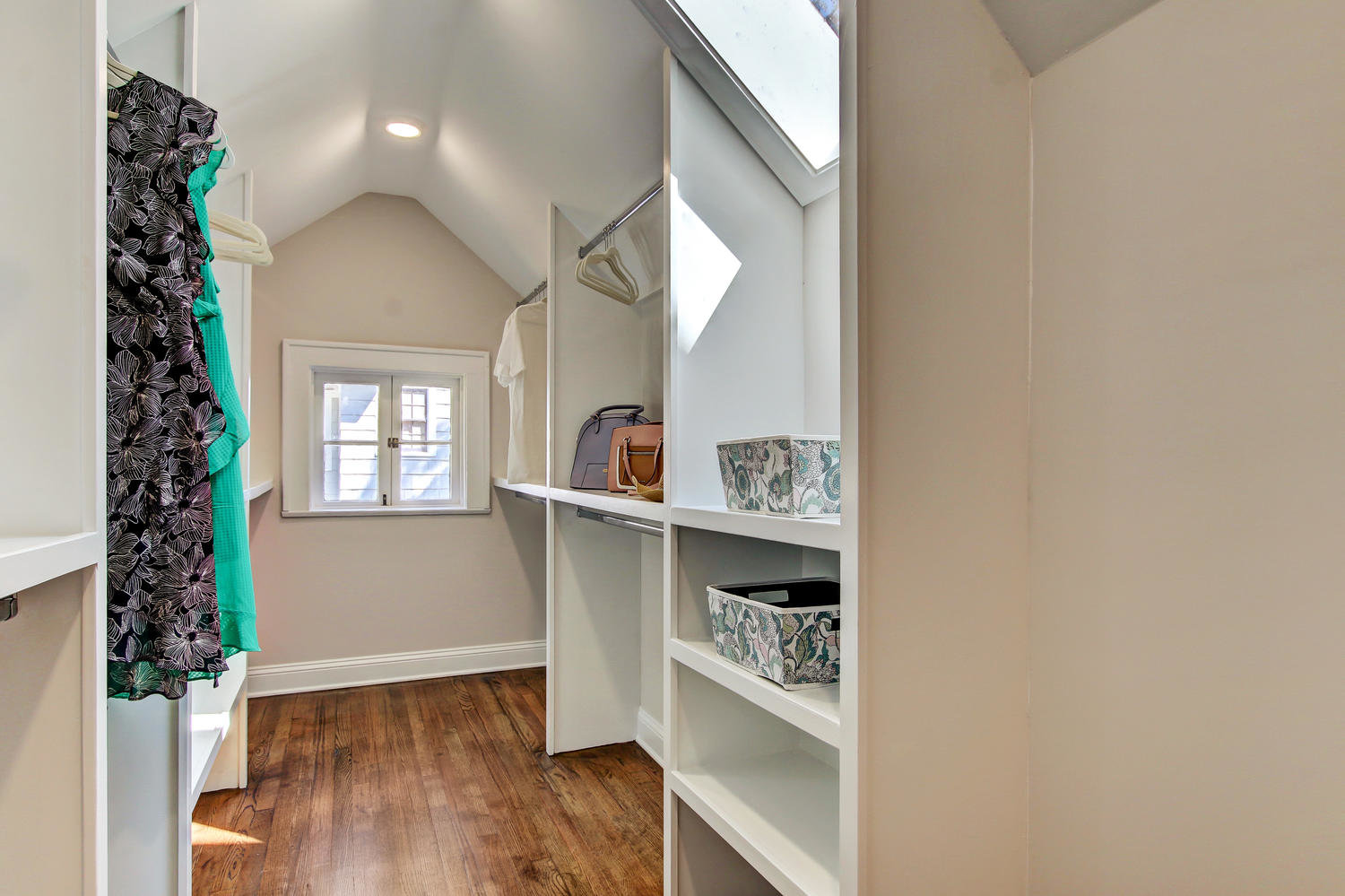 Large walk-in closet  with shelves and skylight